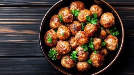Fried meatballs in a bowl garnished with fresh parsley.