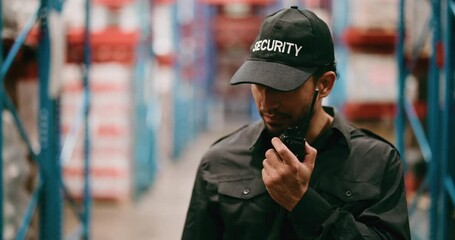 Man, security and warehouse surveillance with radio for inventory safety, inspection or check. Male person, officer or guard walking with signal for communication or supply chain defense in depot - Powered by Adobe