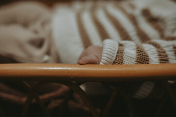 Le petit doigt d'un petit bébé dans son berceau bohème 