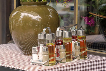 Set of containers for salt pepper oil and vinegar for use at a dining table