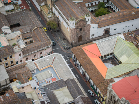 Aerial view of the historic architecture and vibrant rooftops of Quito, a symphony of terracotta hues and colonial structures, blending seamlessly with the urban landscape, Quito, Ecuador. - Powered by Adobe