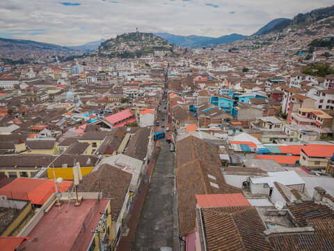 Aerial view of the historic city unfolds with terracotta rooftops leading to the distant Panecillo hill crowned by the Virgin of Quito statue, Quito, Ecuador.