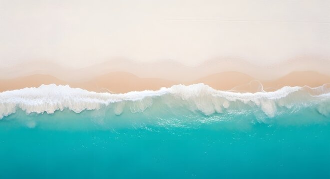 Drone view of a white beach with a light blue sea, as if divided into two sides, the sea side and the beach side.