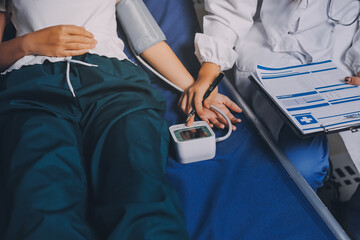 Nurse measuring blood pressure of elderly woman at table, closeup. Assisting senior generation