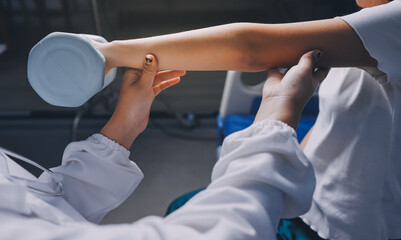 old woman training with physiotherapist using dumbbells at home therapist assisting senior woman with exercises in nursing home elderly patient using dumbbells with outstretched arms no logos no bran