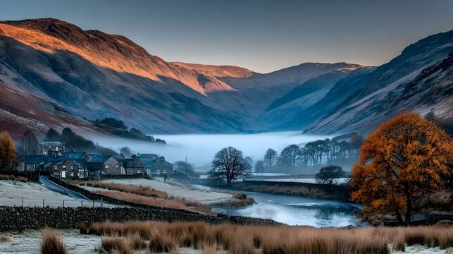 A valley with a lake and autumn trees is shrouded in mist at dawn.