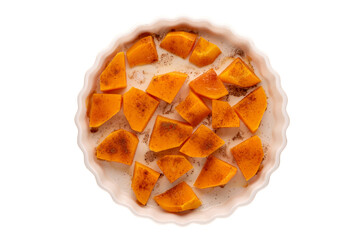 Sweet baked pumpkin slices with cinnamon on a ceramic plate, top view, macro.