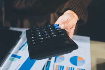 Close-up of businessman's hands making notes, mobiles, chart, desk, office