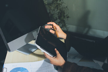 Close-up of businessman's hands making notes, mobiles, chart, desk, office
