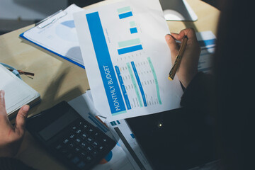 Close-up of businessman's hands making notes, mobiles, chart, desk, office