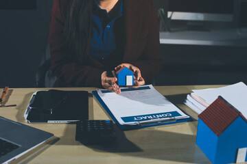 Customer signing a real estate contract in real estate agency.