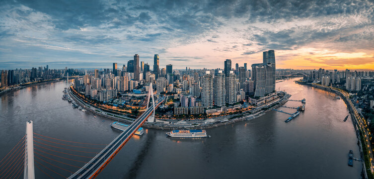 Aerial panorama of the modern city skyline with illuminated buildings and bridges over the river at dusk in Chongqing. - Powered by Adobe