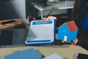 Customer signing a real estate contract in real estate agency.