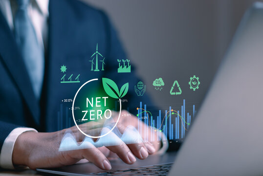 Closeup of businessman's hands typing on laptop with Net Zero icon and green energy symbols. Concept of sustainability strategy, carbon neutrality, renewable energy, ESG data and climate action