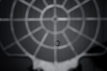 Intricate details of a metal ring against a patterned backdrop create a captivating visual exploration in black and white