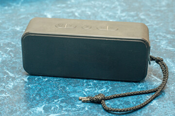 Portable Bluetooth speaker with a textured surface, a compact and stylish device for listening to music anywhere, ideal for travel and outdoor activities