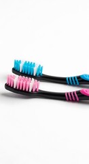 Two Toothbrushes with Pink and Blue Bristles on White Background.