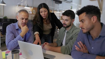 Diverse business team collaborating at a meeting table using one shared laptop. Coworkers working together to analyze data and plan company strategy. Business teamwork concept. - Powered by Adobe