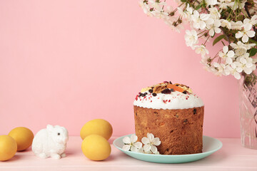 Traditional easter cakes with colorful sprinkles, with eggs, a bunny figurine, and spring flowers, creating a festive holiday scene