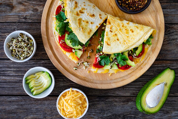 Healthy breakfast - italian piada wraps with scrambled eggs, tomatoes, avocado, coriander and bean sprouts. Top view