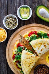 Healthy breakfast - italian piada wraps with scrambled eggs, tomatoes, avocado, coriander and bean sprouts. Top view