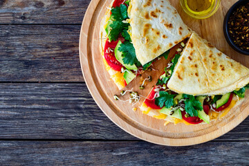 Healthy breakfast - italian piada wraps with scrambled eggs, tomatoes, avocado, coriander and bean sprouts. Top view