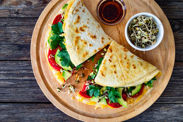 Healthy breakfast - italian piada wraps with scrambled eggs, tomatoes, avocado, coriander and bean sprouts. Top view