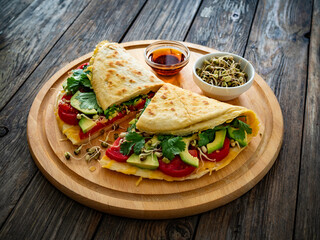 Healthy breakfast - italian piada wraps with scrambled eggs, tomatoes, avocado, coriander and bean sprouts