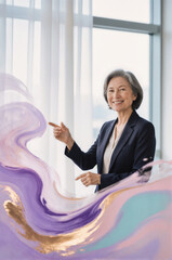 A professional woman in a business suit pointing at an abstract colorful swirl of purple, gold, and pink paint in front of a bright window.