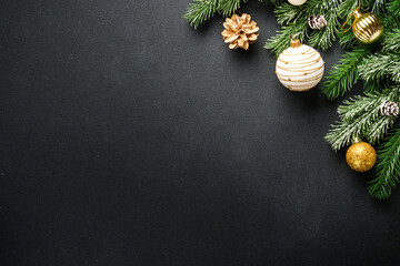 Christmas decorations and spruce tree at black background. Flat lay with copy space.