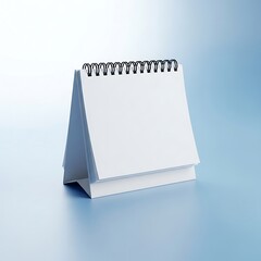 Blank spiral bound desk calendar with white pages on a blue background