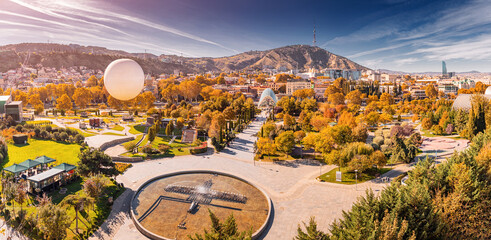 Panoramic view of Rike Park in Tbilisi, Georgia, with golden autumn trees creating a vibrant cityscape © EdNurg