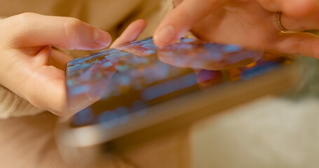 Woman casually scrolling digital social media feed on smartphone screen, engaging with online content through mobile device interface