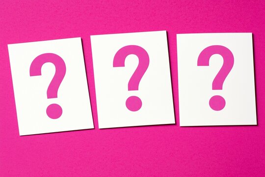 Three Pink Question Mark Cards on Vibrant Magenta Background.