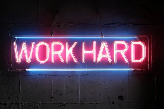 Work hard neon sign glowing pink and blue, mounted on a dark concrete wall - Powered by Adobe