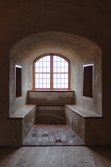 Fototapeta premium Old castle interior with antique furniture, stone walls, and warm light creating a medieval atmosphere full of history and mystery.
