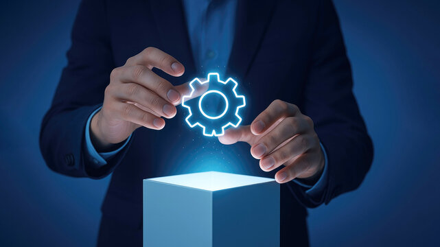 Businessman presenting a glowing gear icon above a light emitting cube technology concept