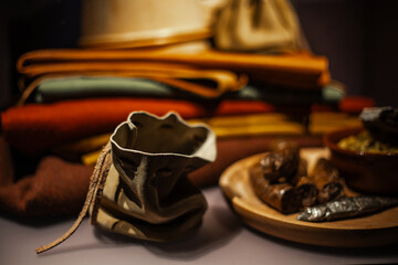 A collection of various antique objects inside a medieval castle: wooden chests, metal locks, ancient tools, sculptures, books, candles, and decorative elements. Warm light highlights textures, materi
