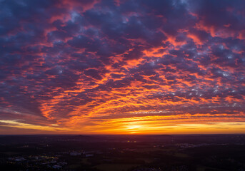 Obraz premium Dramatic Red and Orange Sunset Clouds Over Cityscape Scenery Skyline