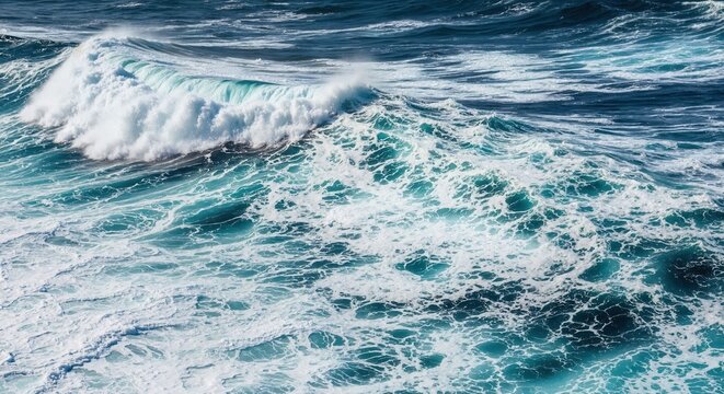 A powerful ocean wave breaking in rough turquoise seas. Close-up of sea foam and turbulent water. Abstract nature background of raw energy
