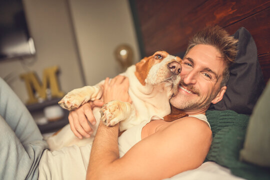 man and her Basset dog at home bed - Powered by Adobe