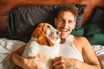 Obraz premium man and her Basset dog at home bed