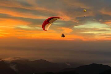 Paragliding over the clouds sunset view at Bir Billing Himachal Pradesh India. Clouds in the sky, Dhauladhar peaks view