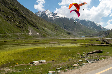 Tourists paragliding 3 pm 6 june 2025 at Leh Ladakh with view of Himalayan mountain range.