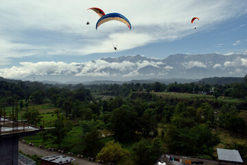 Paragliding over the clouds at Bir Billing Himachal Pradesh India. Clouds in the sky, Dhauladhar peaks view