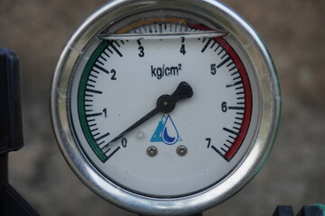 Close-up of water pressure gauge dial showing readings in kg/cm²