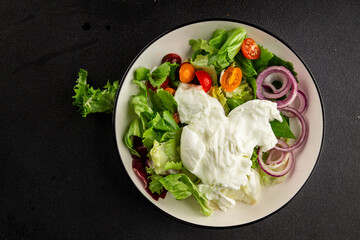 Burrata salad tomato, purple onion, green leaf lettuce tasty snack fresh gourmet food table setting rustic food top view copy space keto and paleo diet vegetarian food