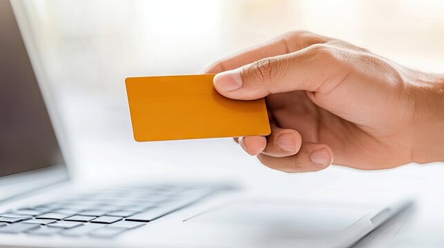 Nighttime cyber threat as a hand of a thief grasps a credit card near a laptop