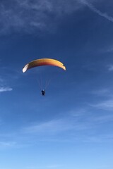 Paraglider soaring through the open sky