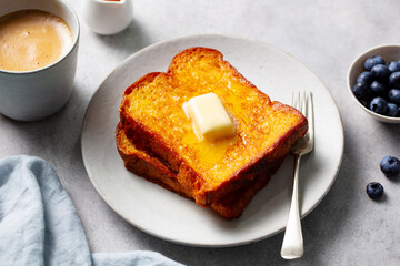 Delicious French toast breakfast with blueberries and coffee. Light grey background. Close up.